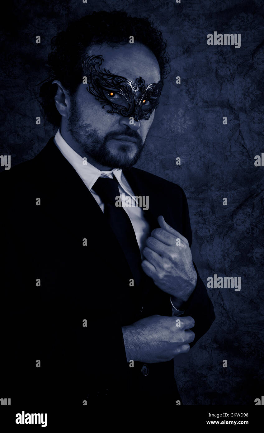 Vampire masked mystery man and elegant black suit over vintage b Stock Photo