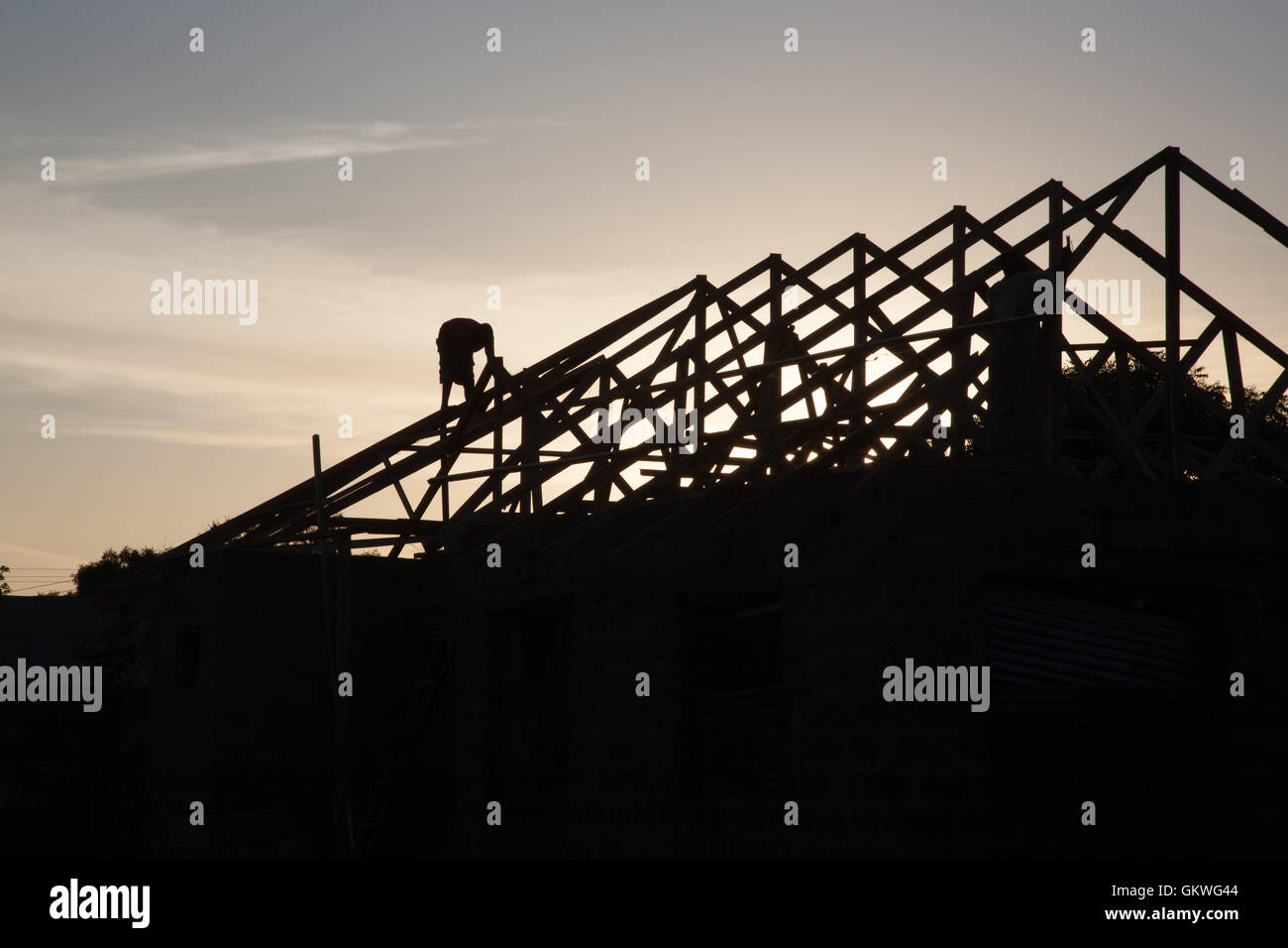 Men work on a house at dusk in moshi, Tanzania Stock Photo