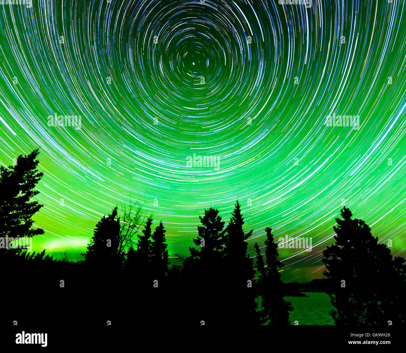 Star trails around Polaris and Northern lights Stock Photo