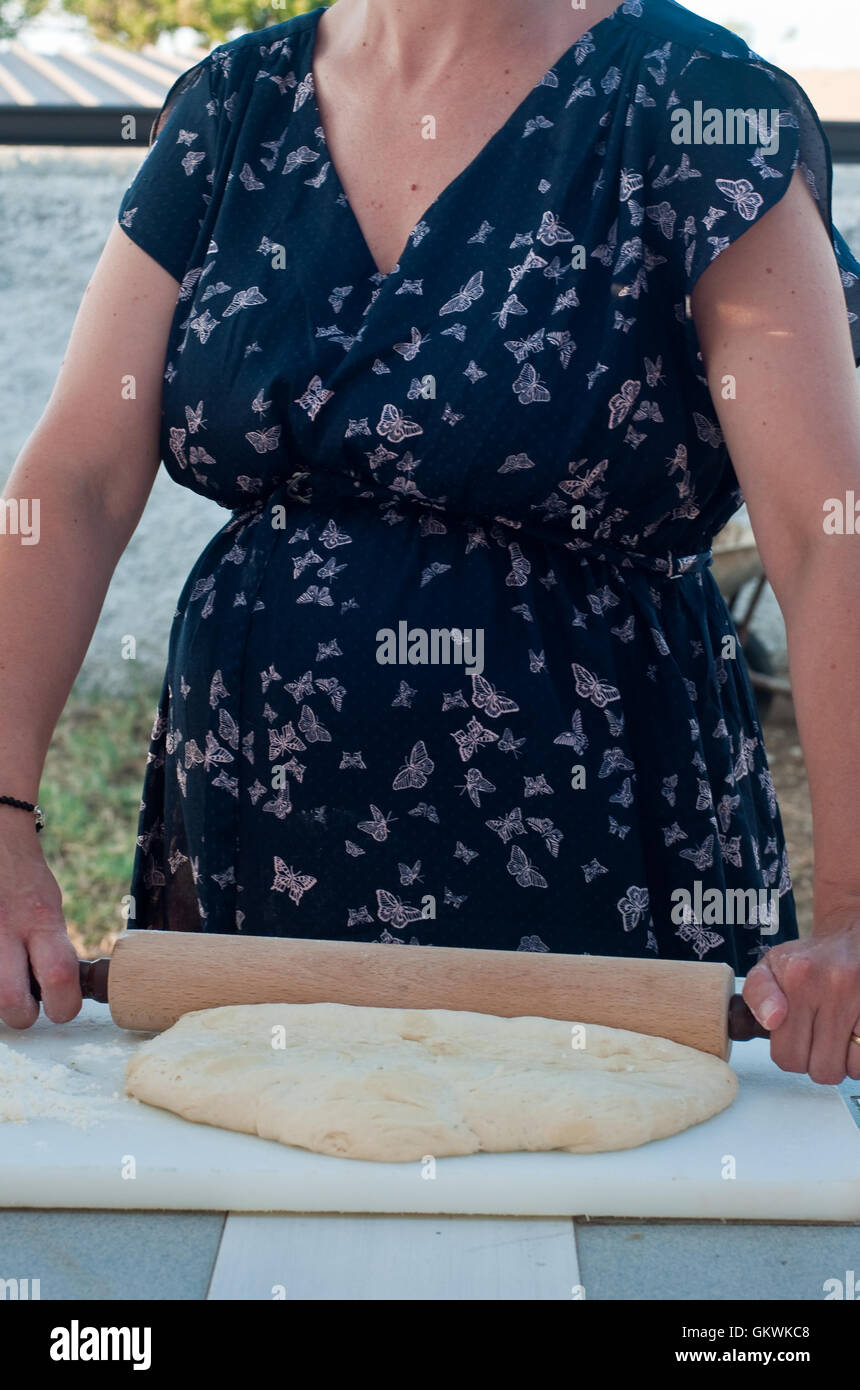 young and beautiful girl who stretches out his pizza with a rolling pin Stock Photo