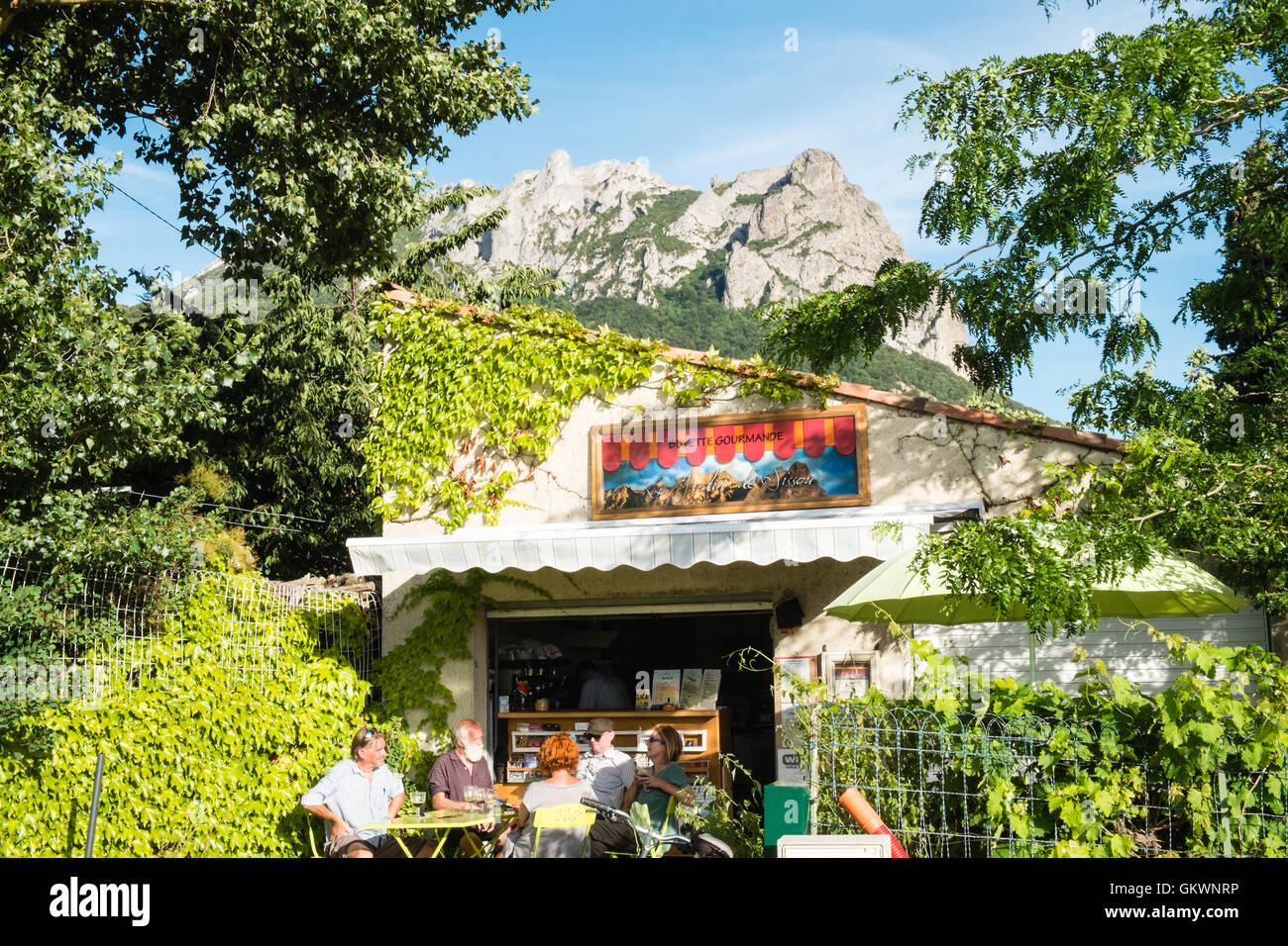 Bugarach Mountain in background,backdrop and guests sitting at small cafe in Bugarach,Aude Province,South of France. Stock Photo
