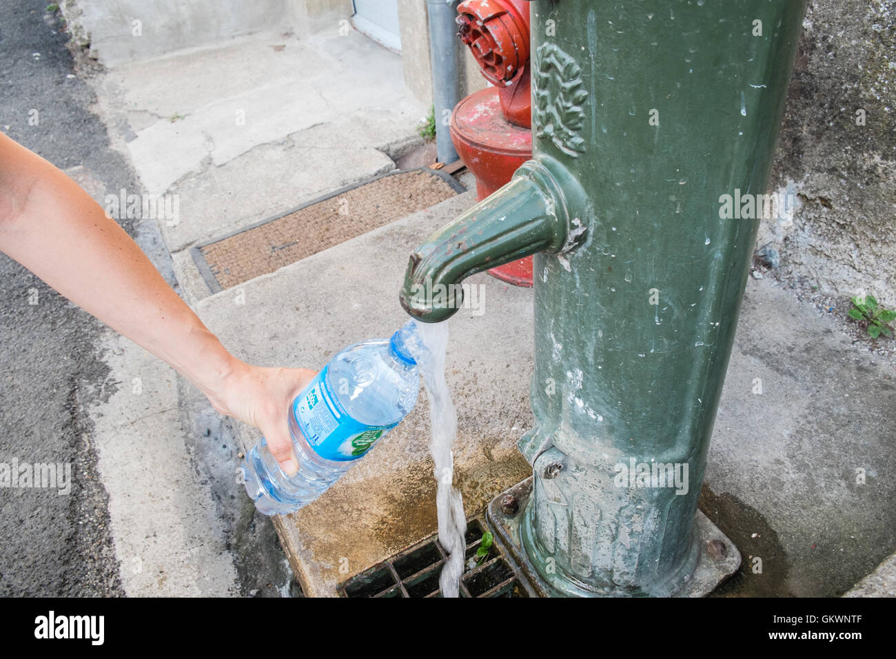 Filling water bottle at public water stand fountain pump,tap,water
