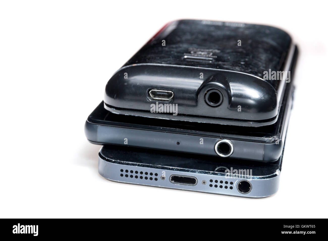 Stack of an android smartphone, iphone and portable radio showing their headphone sockets. Stock Photo
