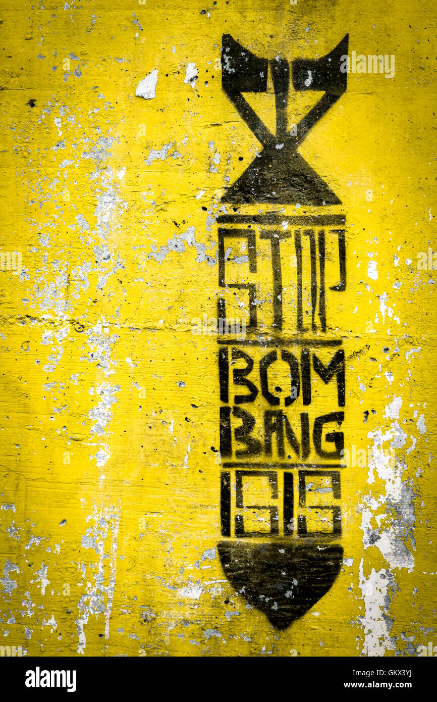 Graffiti on the wall depicting the silhouette of a bomb. Inside the message 'STOP ISIS'. Stock Photo