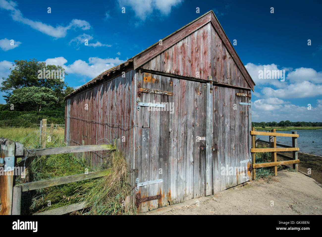 Old wooden boathouse on the edge of a waterway Stock Photo