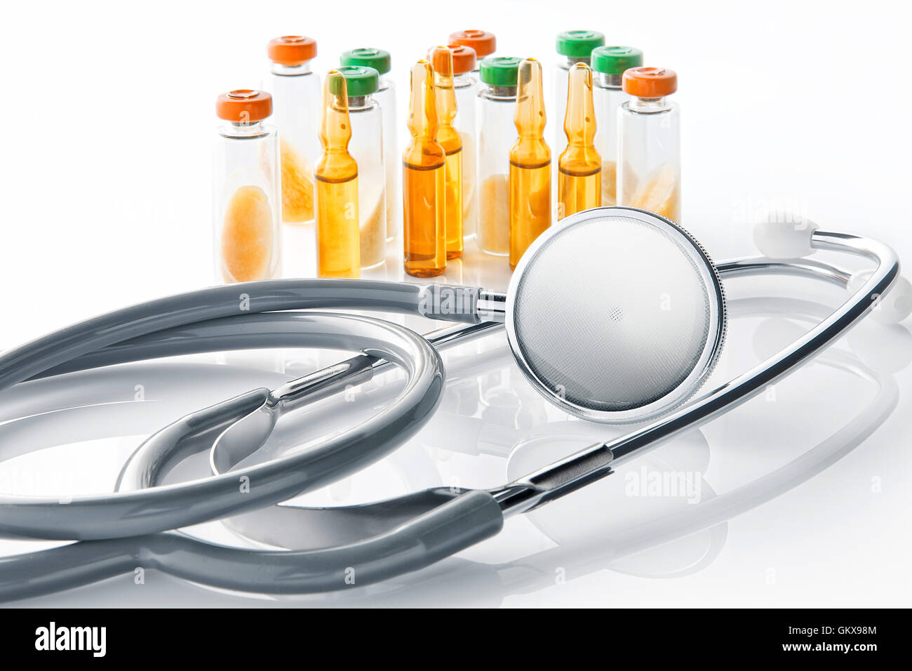 Close up view of grey stethoscope and ampoules on white back Stock