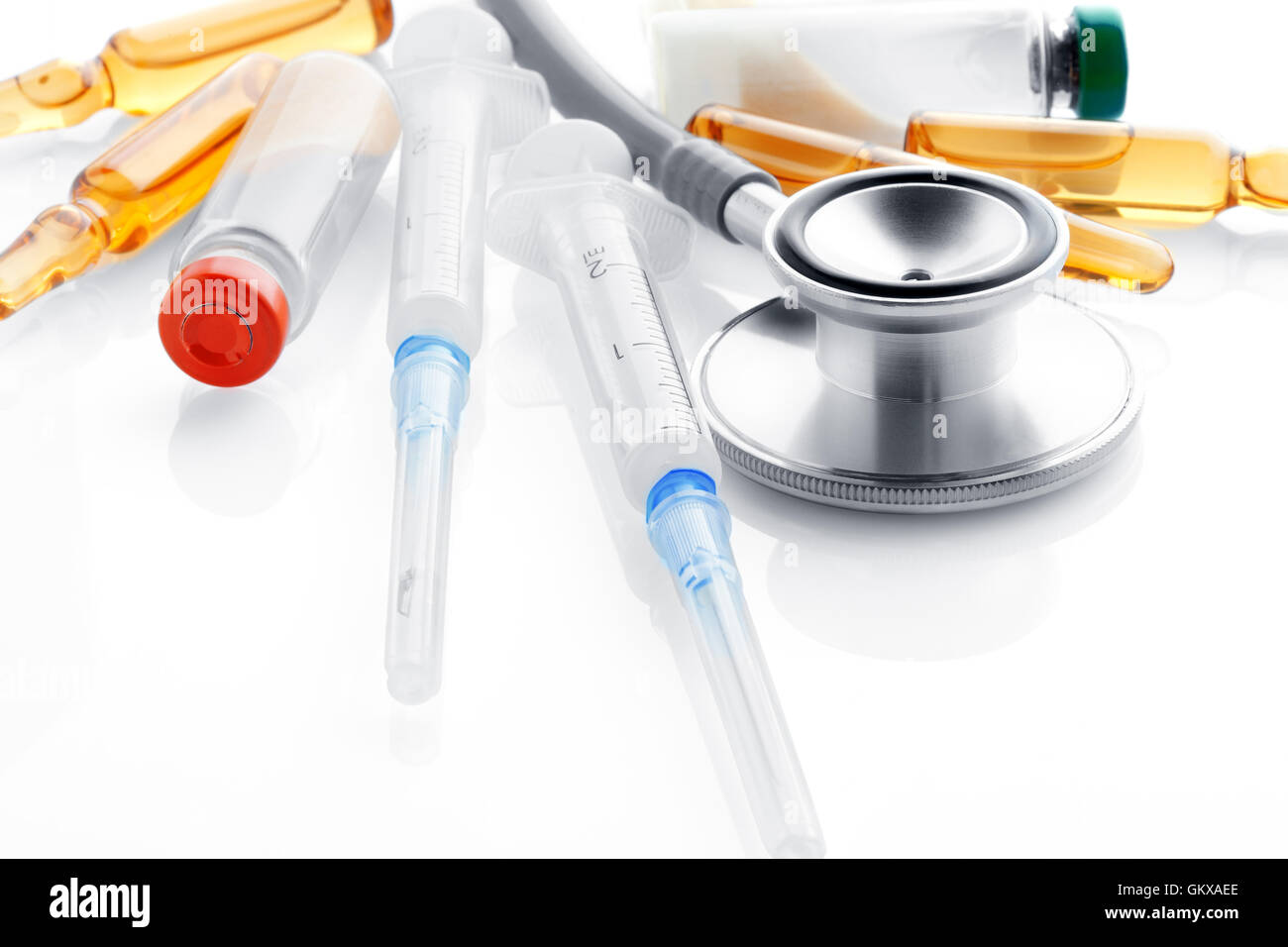 Close up view of grey stethoscope and ampoules on white back Stock