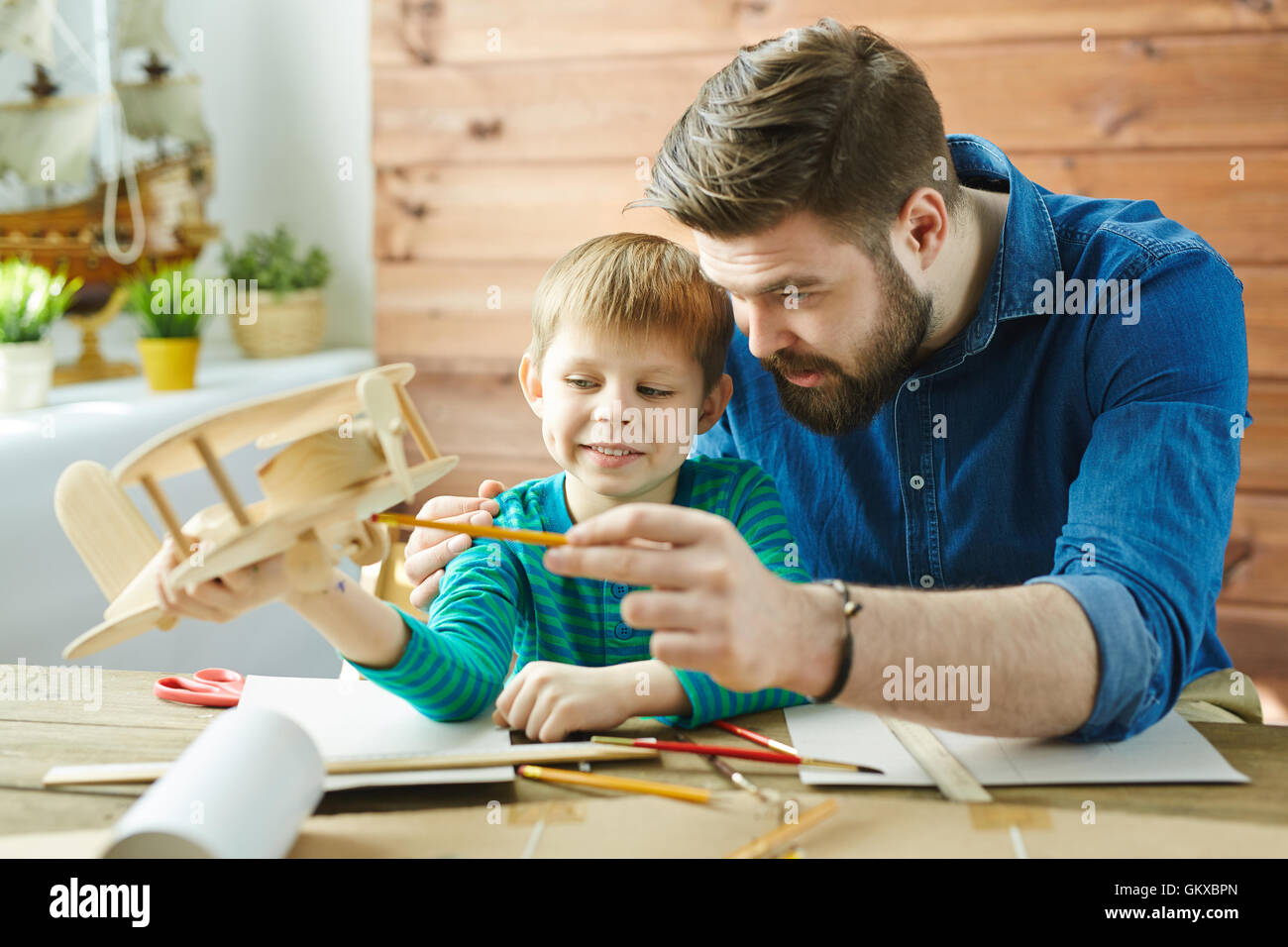 Father explaining his son structure of detail of wooden airplane Stock Photo