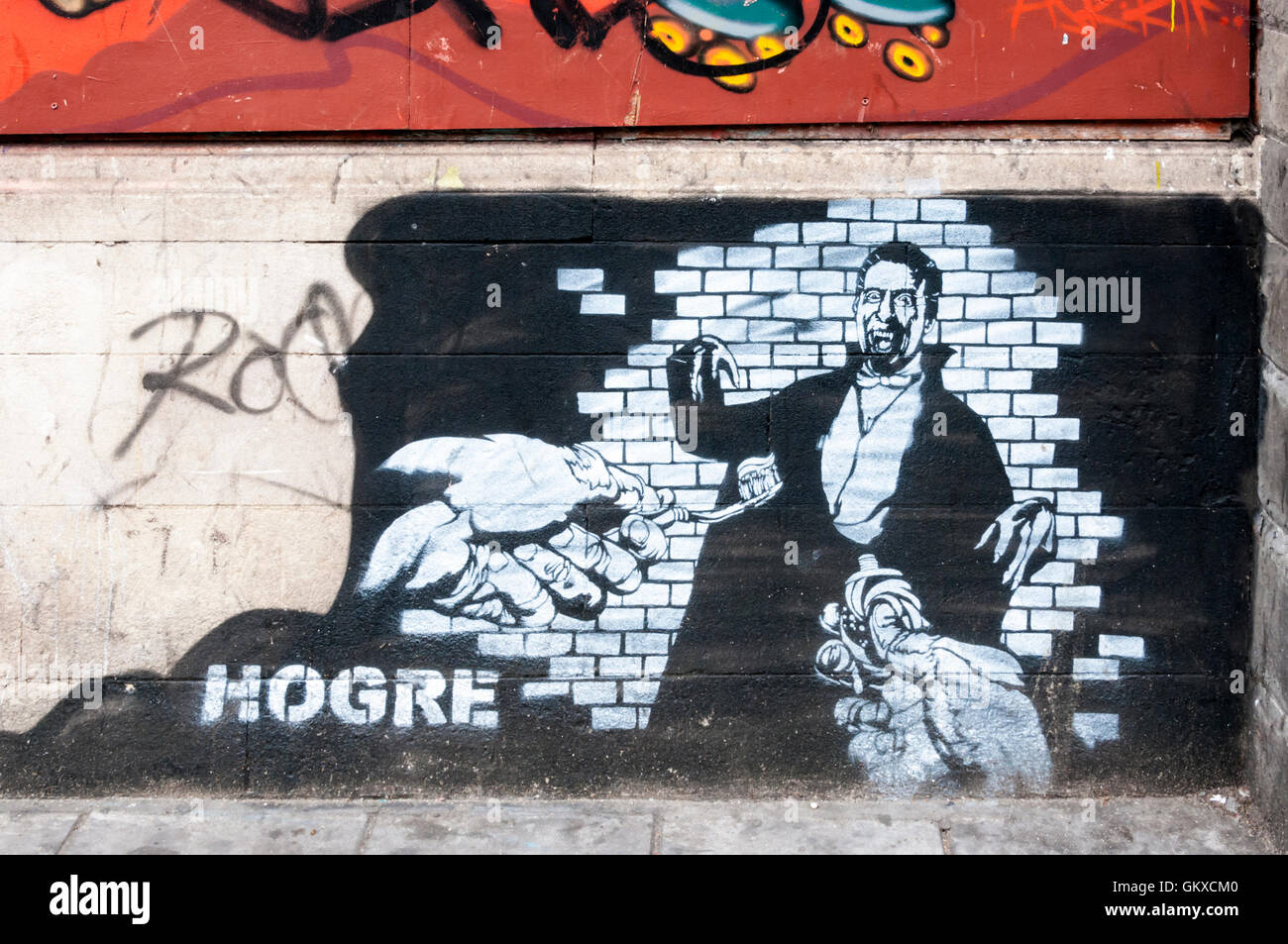 Graffiti by Hogre in Stokes Croft area of Bristol shows a vampire, possibly Dracula, being offered toothpaste & a toothbrush. Stock Photo