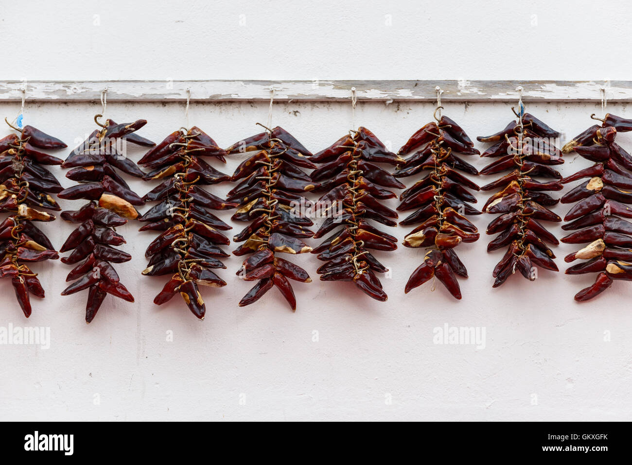 Strings of PDO Espelette chilli peppers drying, France Stock Photo
