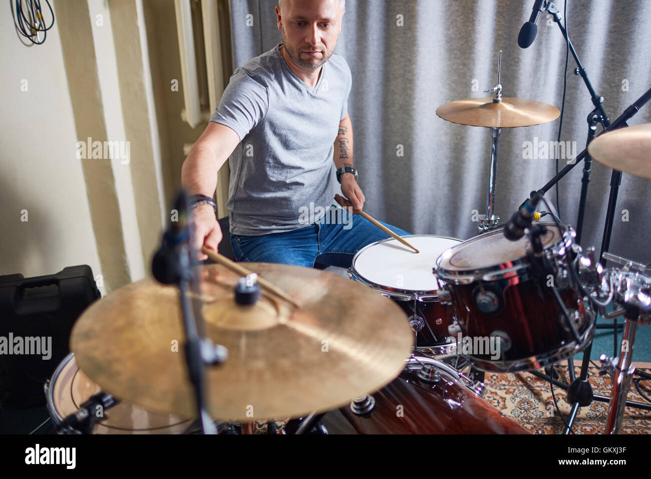 Modern performer playing drums and cymbals in studio of sound Stock