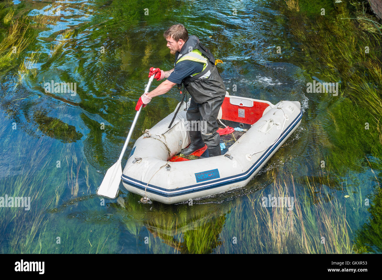 Man Standing Rowing Inflatable Dingy in River Stock Photo
