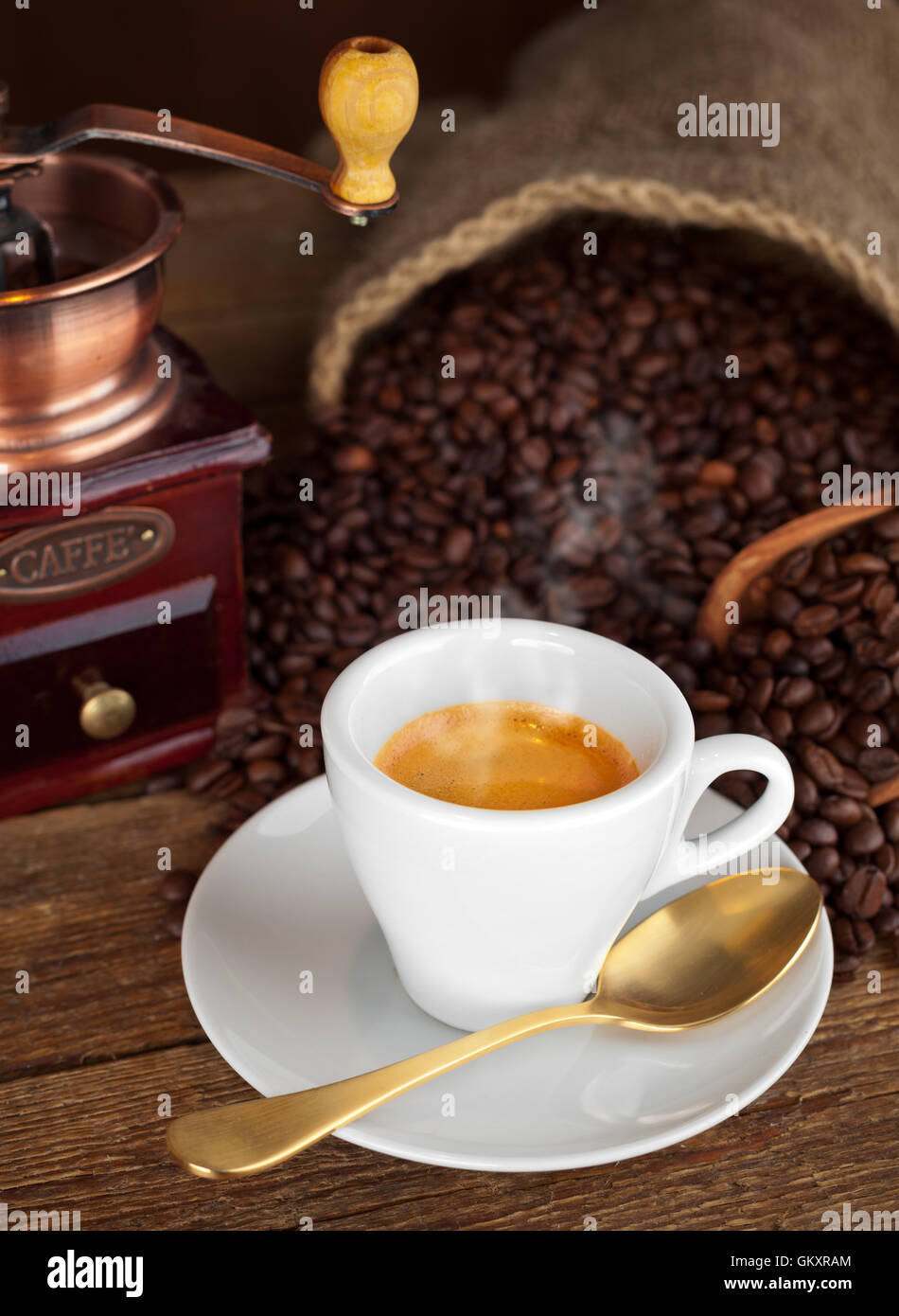 Cup of espresso coffee, coffee beans and old coffee grinder on the