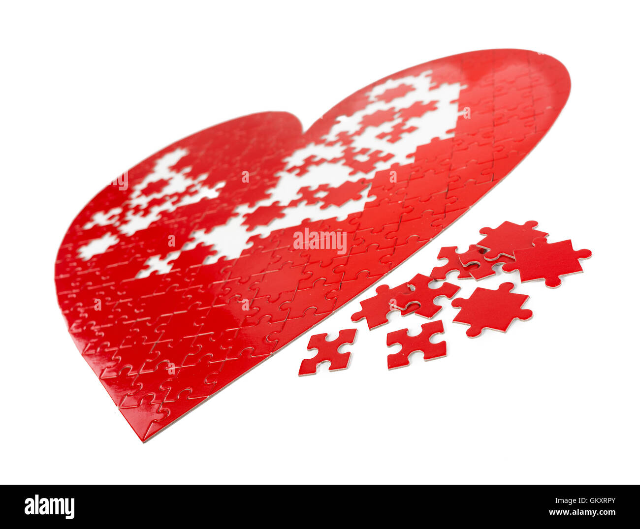 Red puzzle heart shape on white background. Stock Photo