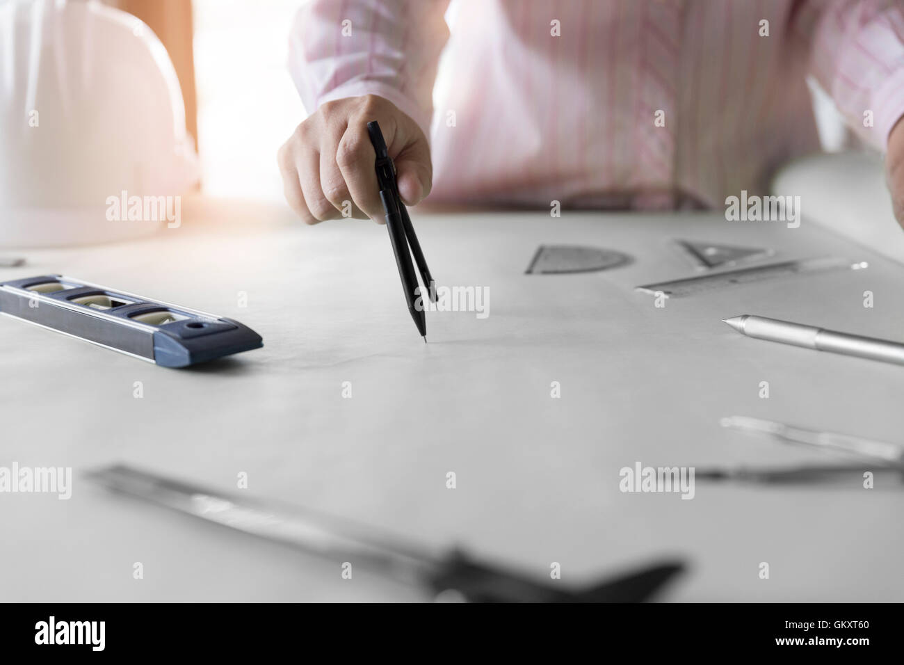 architect hand holding compass working on construction engineering