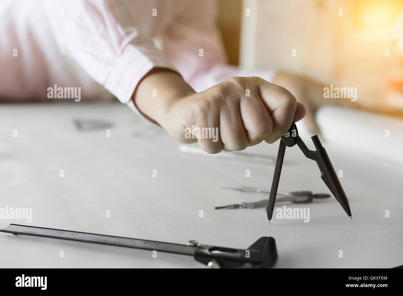 architect hand holding compass working on construction engineering