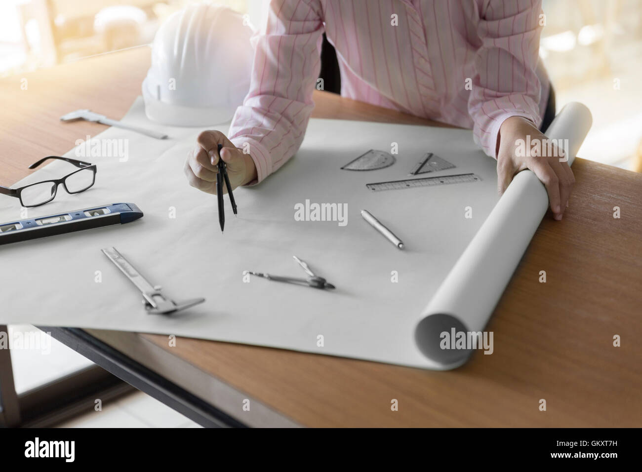 architect hand holding compass working on construction engineering project blueprint Stock Photo