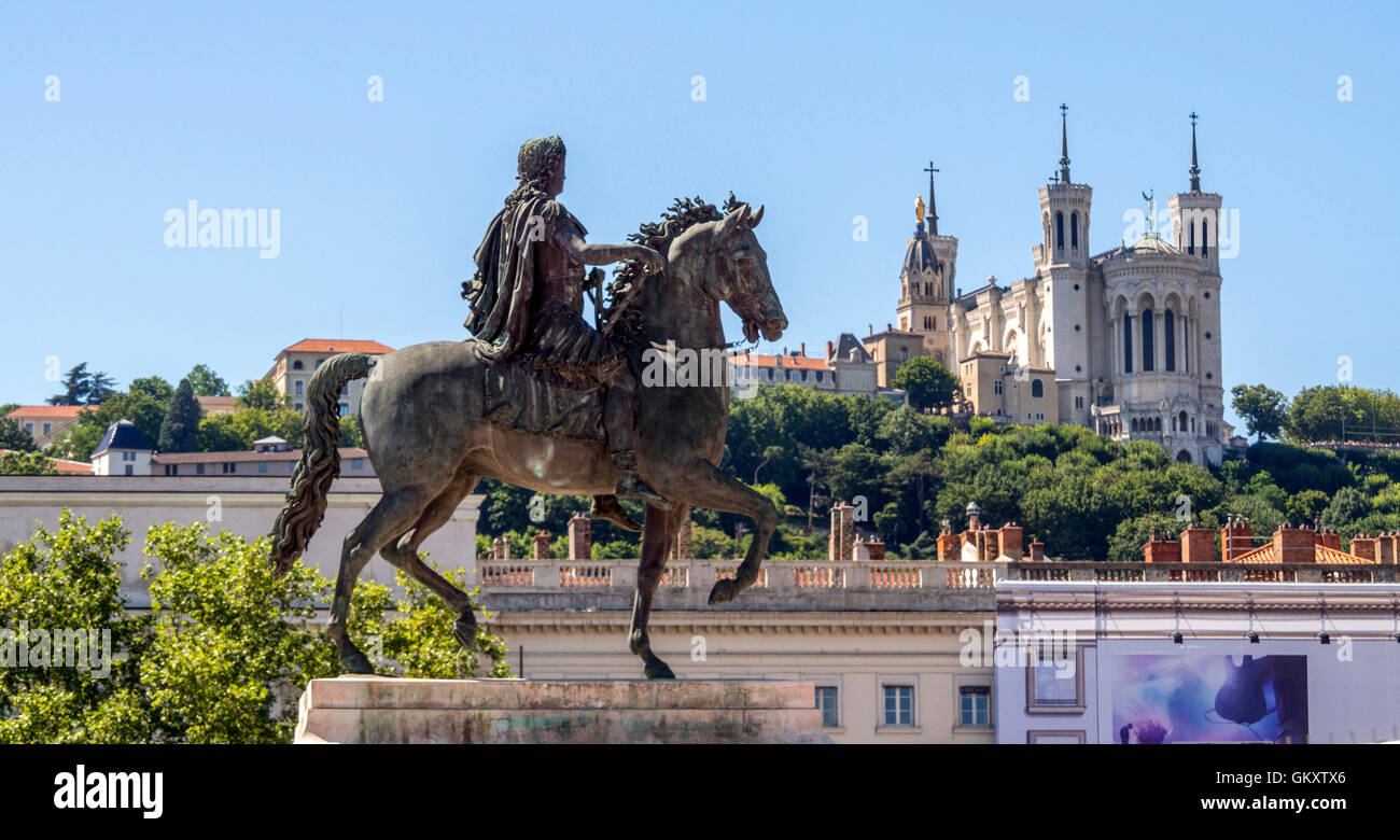 Lyon 2e arr. Statue of King Louis XIV and Fourviere basilica on a background. Place Bellecour. Rhone. Frace Stock Photo