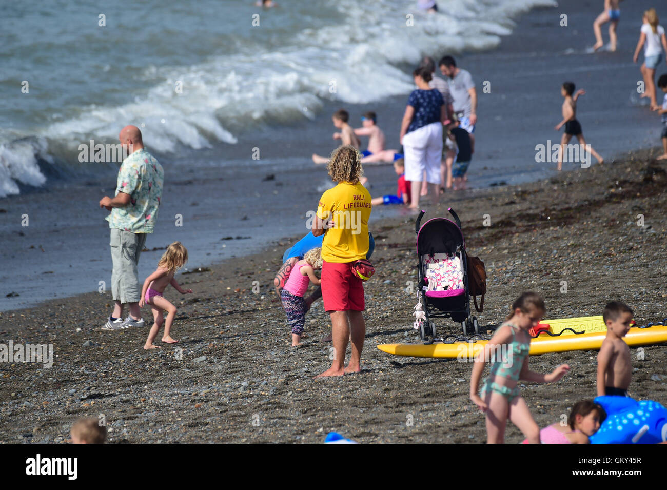 Aberystwyth, Wales, UK. 23rd Aug, 2016. UK weather: PA lifeguard keeps a watchfull eye as people enjoy paddling and swiming in the sea on a warm sunny day at the seaside in Aberystwyth Wales. The Met Office is warning of a mini heatwave in the south east of the UK, with temperatures expected to reach the low 30's centigrade Credit:  keith morris/Alamy Live News Stock Photo