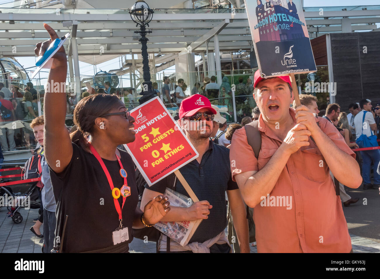 London, UK. August 23rd 2016. A woman from the London Eye tells the Unite Hospitality Workers that they are not allowed on the Embankment walkway, which she says is private property. They met there to launch their 'Unethical London' report into the bullying, harassment and victimisation of workers in London's top hotels, where management deny the right to join unions and bargain for better wages and conditions with a protest close to the London Eye and outside the Premier Inn at London County Hall. Two thirds of hospitality workers earn less than the London Living Wage. Peter Marshall/Alamy Li Stock Photo