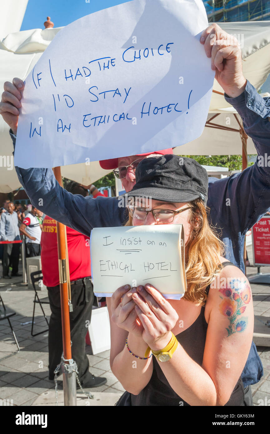 London, UK. August 23rd 2016. Unite Hospitality Workers hold up signs calling for ethical hotels as they meet to launch their 'Unethical London' report into the bullying, harassment and victimisation of workers in London's top hotels, where management deny the right to join unions and bargain for better wages and conditions with a protest close to the London Eye and outside the Premier Inn at London County Hall. Two thirds of hospitality workers earn less than the London Living Wage. Peter Marshall/Alamy Live News Stock Photo