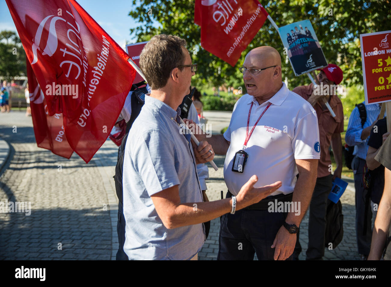 London, UK. 23rd August, 2016. A patrol officer from the Lambeth South Bank Patrol team informs Peter Kavanagh, Unite London Regional Secretary, that members of the Unite Hotel Workers Branch launching their Unethical London report are not permitted to display placards and banners in Jubilee Gardens. Credit:  Mark Kerrison/Alamy Live News Stock Photo
