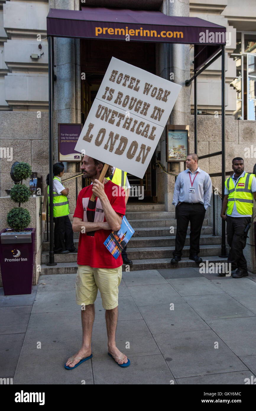 London, UK. 23rd August, 2016. A supporter of the Unite Hotel Workers Branch launches the Unethical London report, which details the manner in which workers at leading London hotels are denied access to the basic human rights of freedom of association and collective bargaining, at a protest outside the Premier Inn at County Hall. Two-thirds of hospitality workers earn less than the London Living Wage. Credit:  Mark Kerrison/Alamy Live News Stock Photo