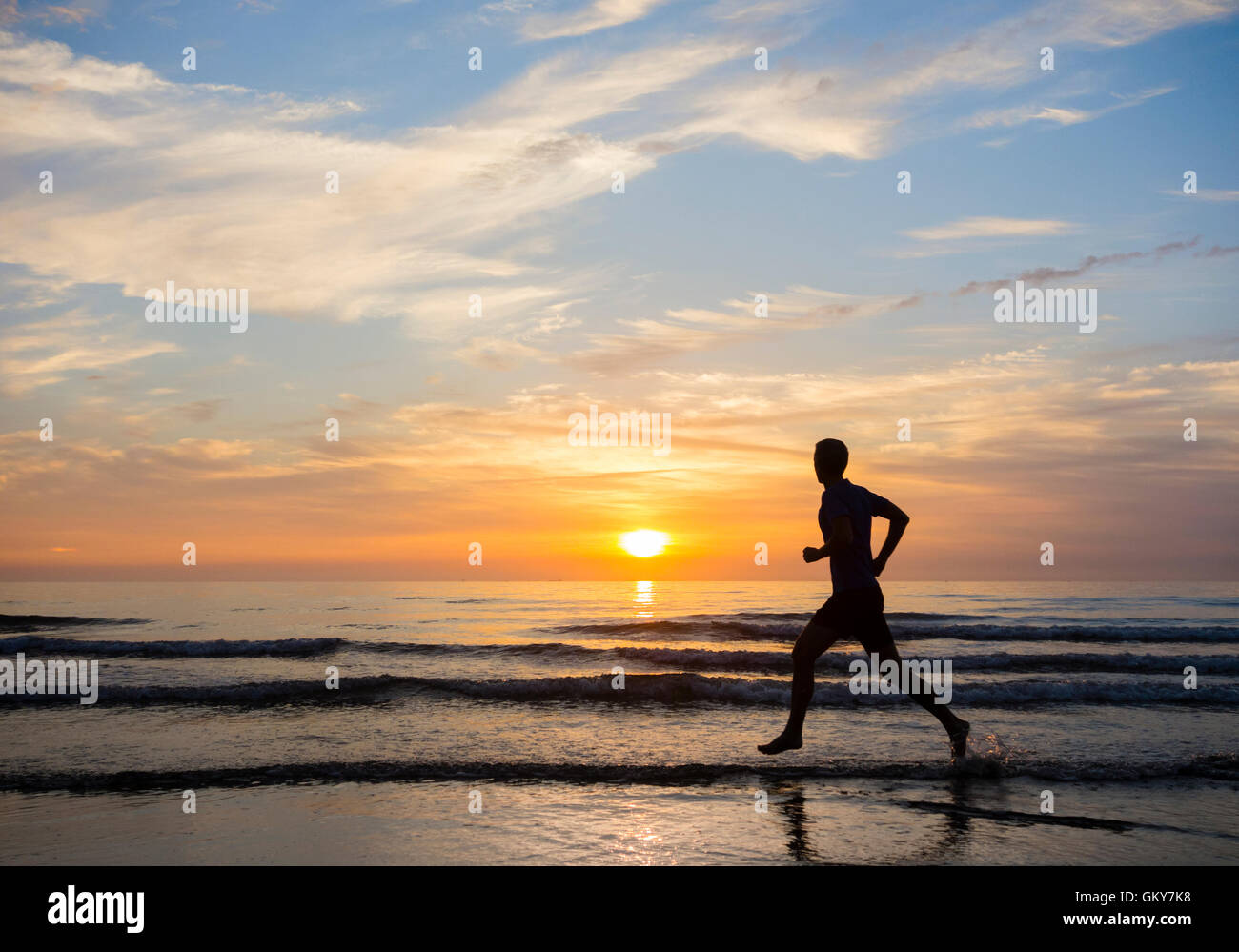 Seaton Carew, north east England, UK, 24th August, 2016. Weather: Costa del Seaton. A jogger cools down in the North sea at sunrise with temperatures already in the mid to high teens Celcius on a glorious Wednesday morning on the north east coast of England. Credit:  Alan Dawson News/Alamy Live News Stock Photo