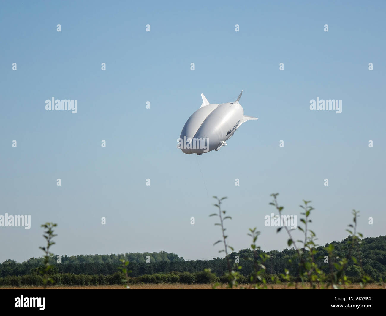Bedfordshire, UK. 24th August, 2016, The Hybrid Air Vehicles (HAV) Airlander 10 undergoing test flights over the Bedfordshire and Hertfordshire countryside. In a steep dive near the Historic RAF Cardington Hangars it is a broad-hulled airship with auxiliary wing and tail surfaces, it flies using both aerostatic and aerodynamic lift. Powered by four diesel-engine driven ducted propellers, it is the largest aircraft flying today.  Within the next hour this aircraft had crash landed at the base station, causing some damage to the cockpit. Photo Credit:  Mick Flynn/Alamy Live News Stock Photo