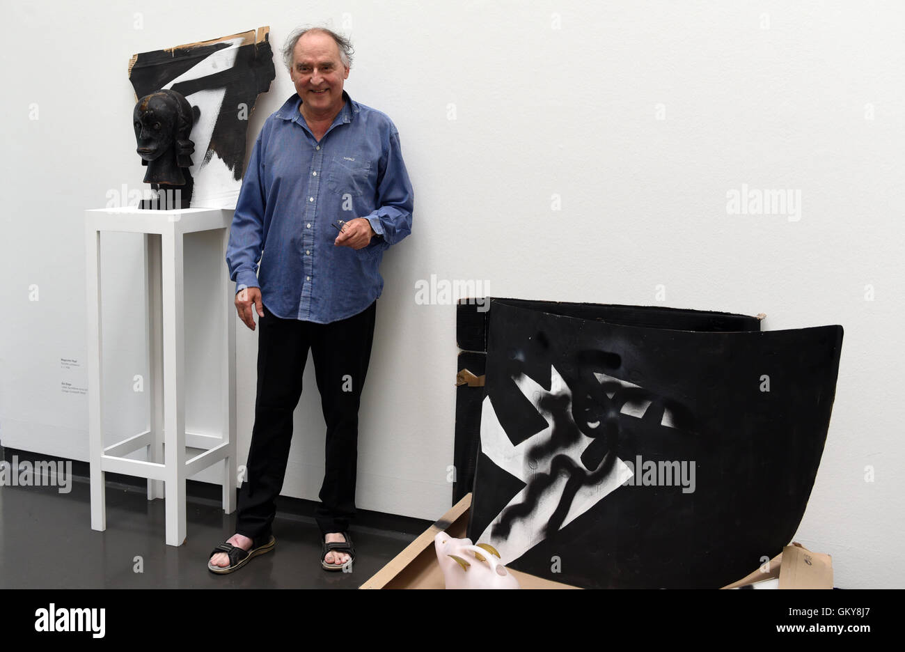 Duesseldorf, Germany. 24th Aug, 2016. Artist Harald Naegeli, who was widely known as 'the sprayer of Zurich' in the 1970s, stands next to some of his artworks in his atelier, that was moved to the museum for the exhibition, during the press tour of his exhibition 'Harald Naegeli - Der Prozess' at the Stadtmuseum in Duesseldorf, Germany, 24 August 2016. The exhibition is open at the Stadtmuseum in Duesseldorf from 26 August 2016 to 1 January 2017. Photo: Horst Ossinger/dpa/Alamy Live News Stock Photo