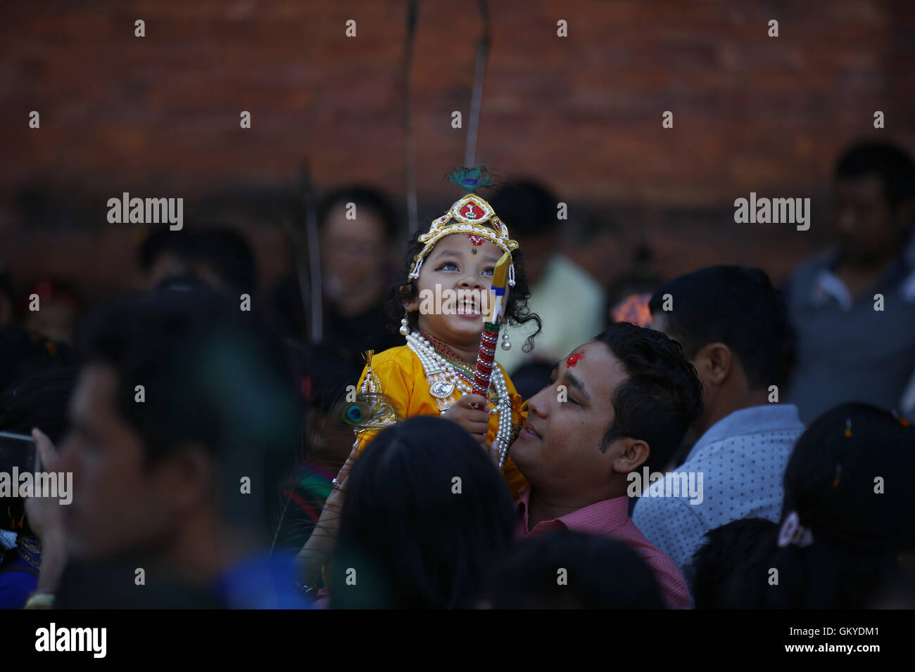 Lalitpur, Nepal. 25th Aug, 2016. A Nepalese boy dressed as Hindu God Krishna reacts in front of Krishna Temple during celebrations of Janmashtami festival or birth anniversary of Deity Krishna in Patan Durbar Square, Lalitpur on Thursday, August 25, 16. Credit:  Skanda Gautam/ZUMA Wire/Alamy Live News Stock Photo