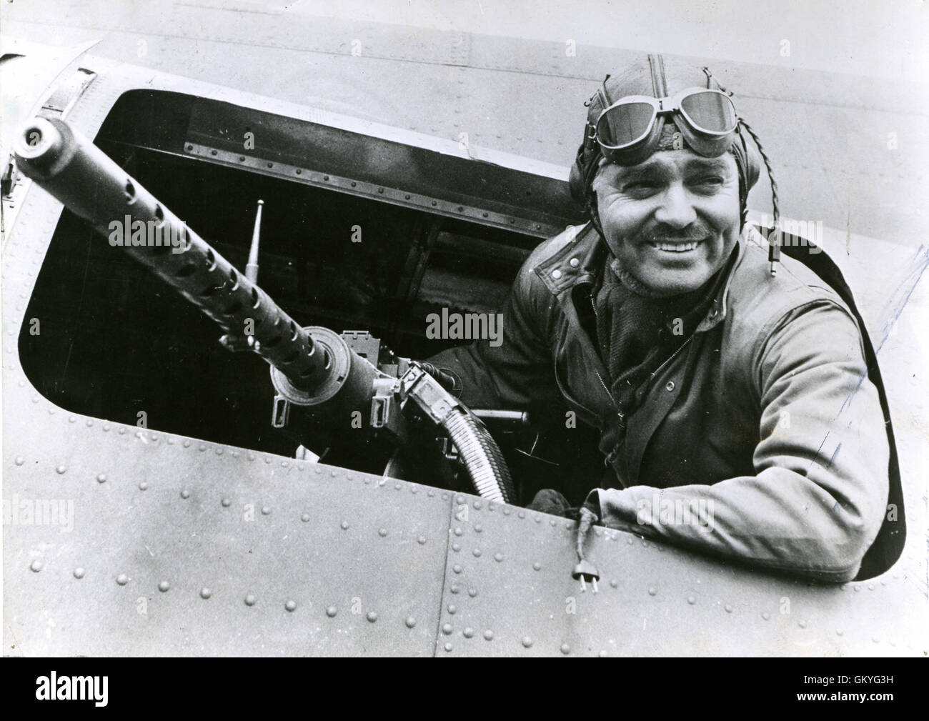 Clark Gable, a former Hollywood motion picture star now serving as a gunnery instructor with the Eighth U.S. Army Air Force in England, sits behind the waist gun of a Flying Fortress bomber at an American air base in England. Stock Photo