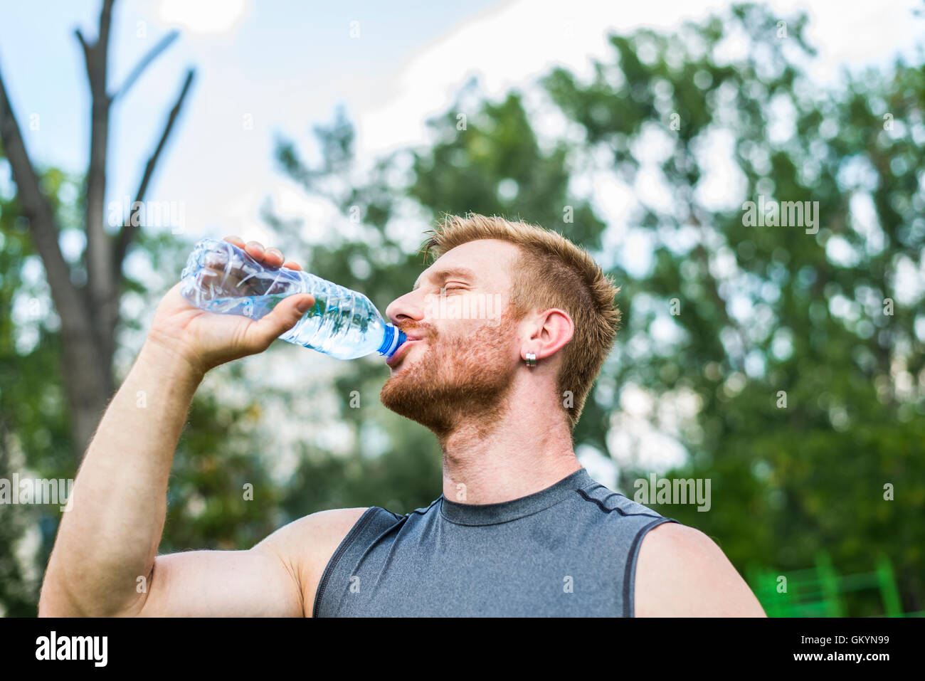 Young athlete drinking water after a workout Stock Photo Alamy