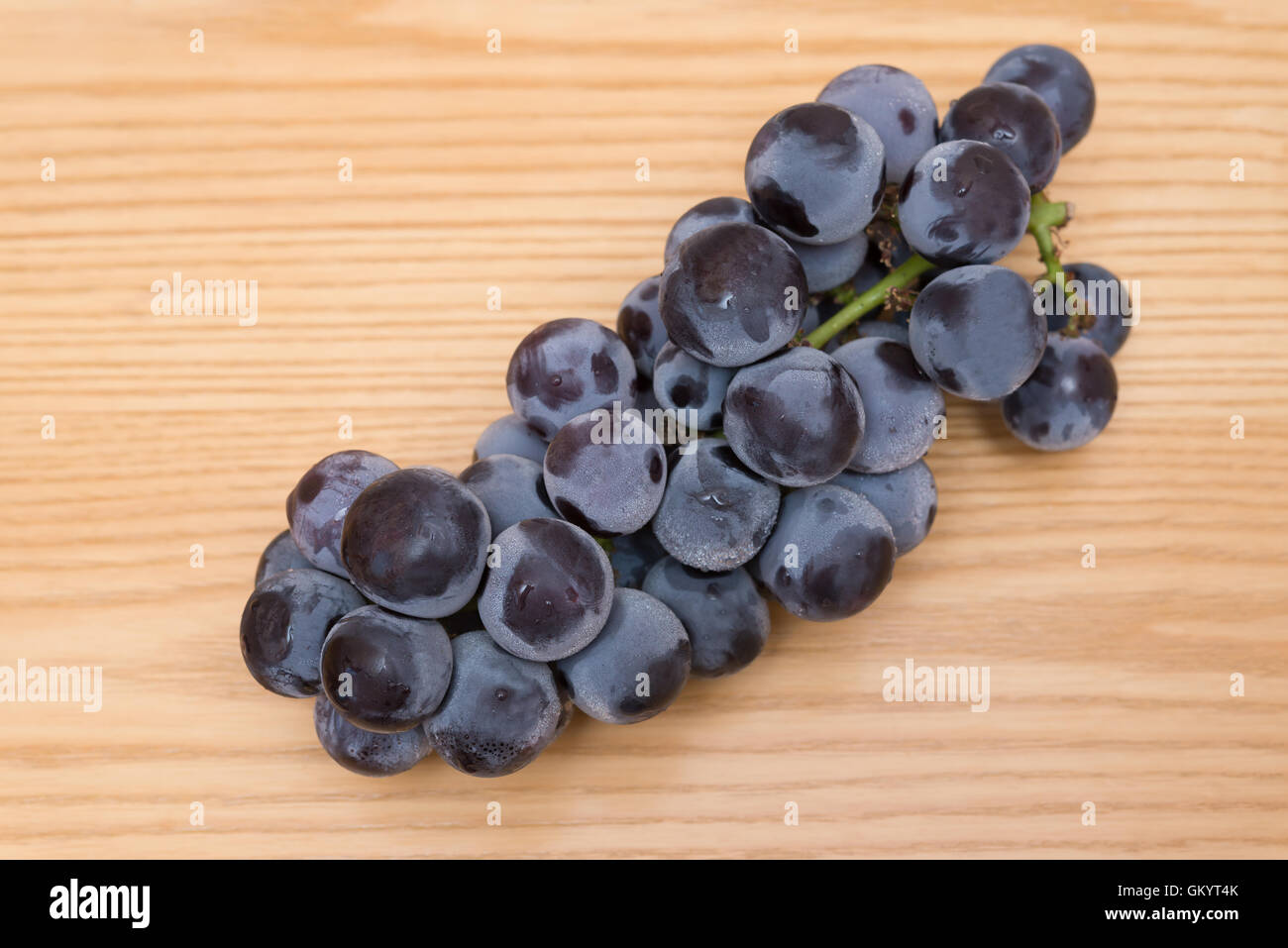 fresh black grapes on a wood table Stock Photo