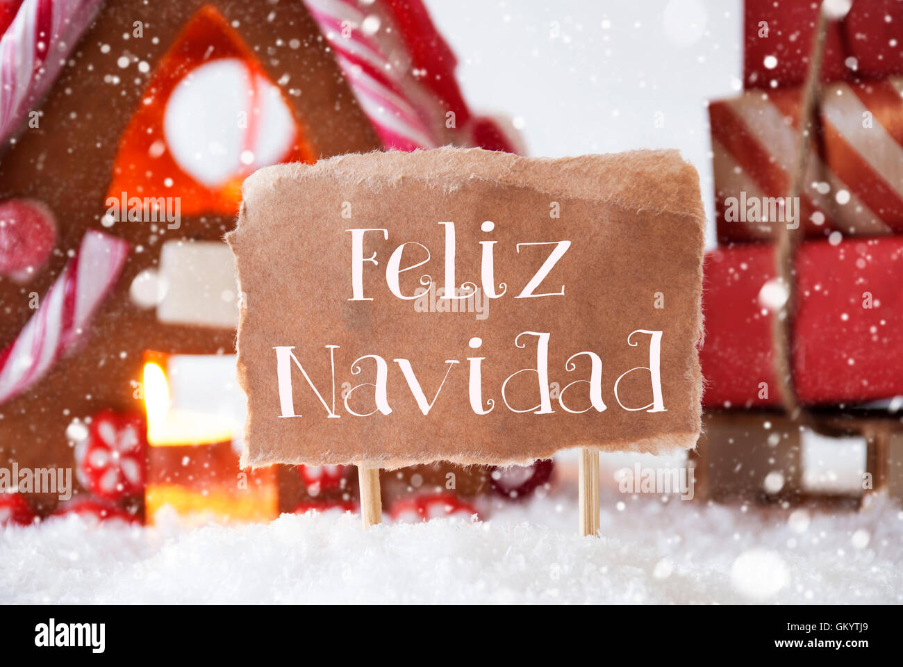Gingerbread House With Sled, Snowflakes, Feliz Navidad Means Merry Christmas Stock Photo