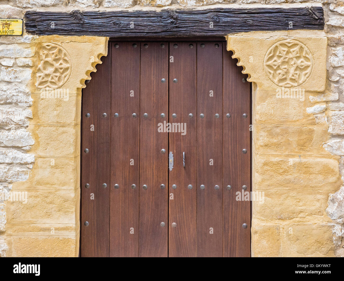 Very old Arabic design in stone supporting a wooden lintel in the historic Albayzín neighborhood in Sabiote, Spain. Stock Photo