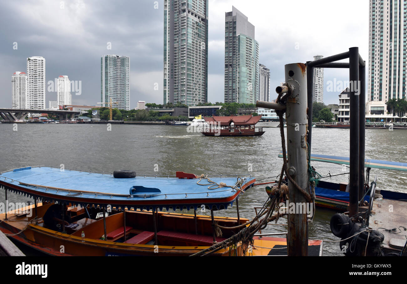 Jetty on the bank of the Chao Phraya River, Bangkok, Thailand, with a view of the high rise tower blocks as seen from Jacks Bar Stock Photo