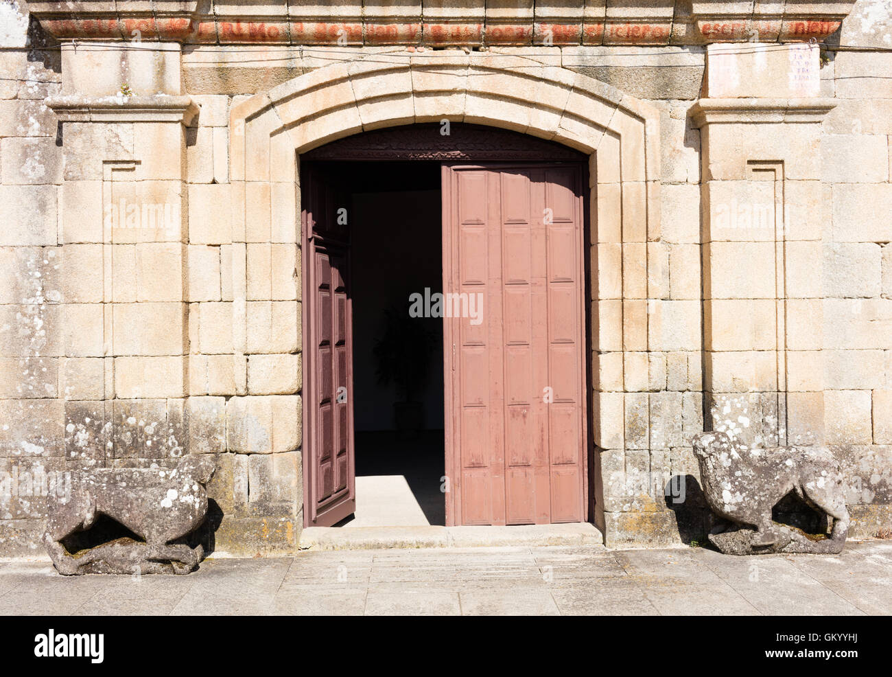 old wooden doors, the wall around is built with stones Stock Photo