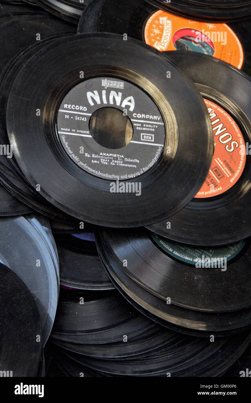 Old records pile of dusty 45s scratched 7' vinyl singles background. Selective focus. Stock Photo
