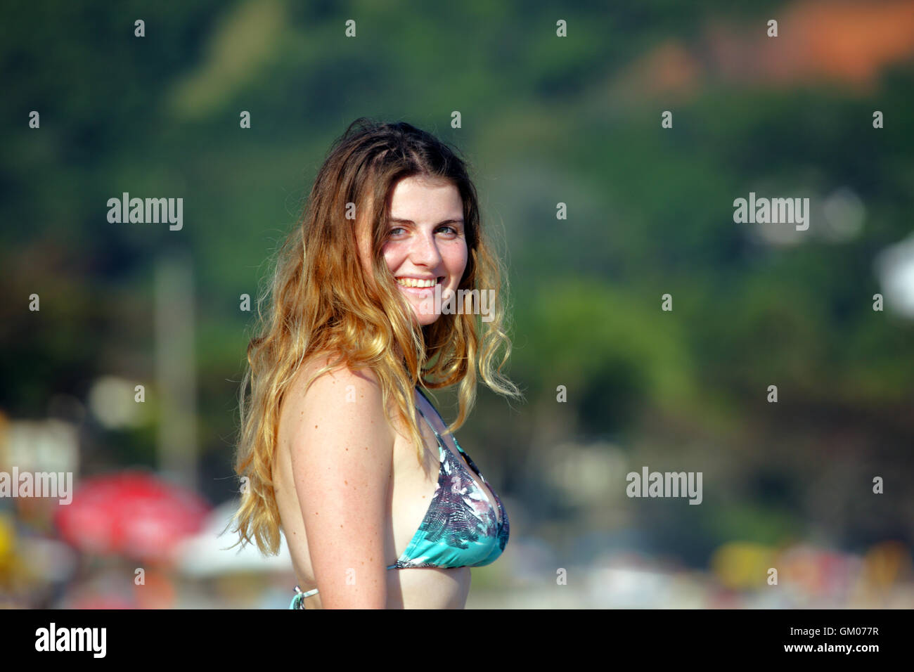 Twenty year old girl smiling and wearing a bikini at the beach Stock Photo