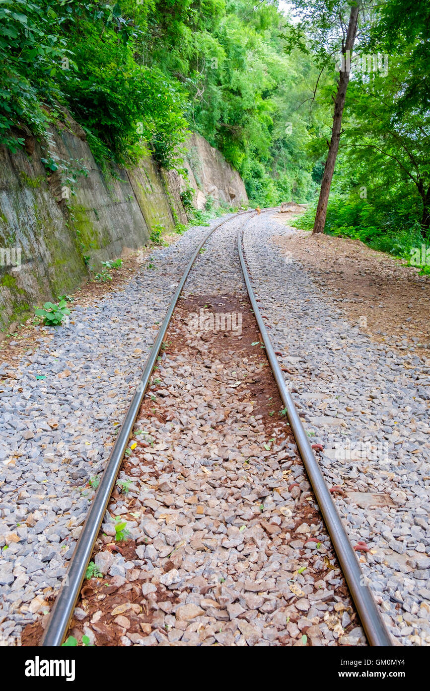The Death Railway along the cliff and tree located at Kanchanaburi, Thailand. Stock Photo
