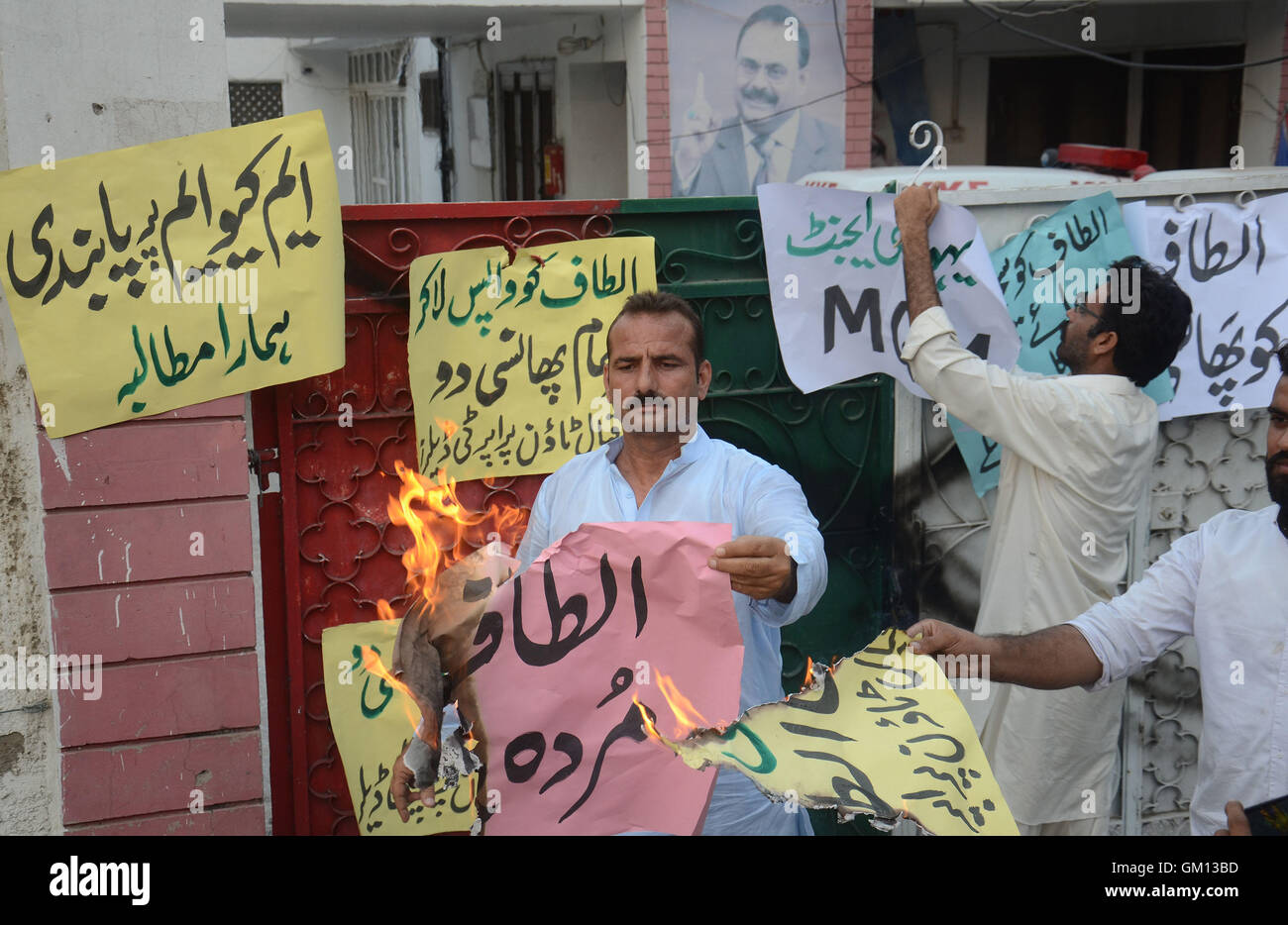 Lahore, Pakistan. 23rd August, 2016. Pakistani activists burning MQM's flag during a demonstration against Altaf Hussain, the leader of Pakistani political Muttahida Qaumi Movement (MQM) party outside the (MQM) Punjab office in Lahore. Pakistani police charged the exiled leader of an influential political party with treason and inciting terrorism, accusing him of provoking violence at a protest a day earlier in Karachi. Credit:  PACIFIC PRESS/Alamy Live News Stock Photo