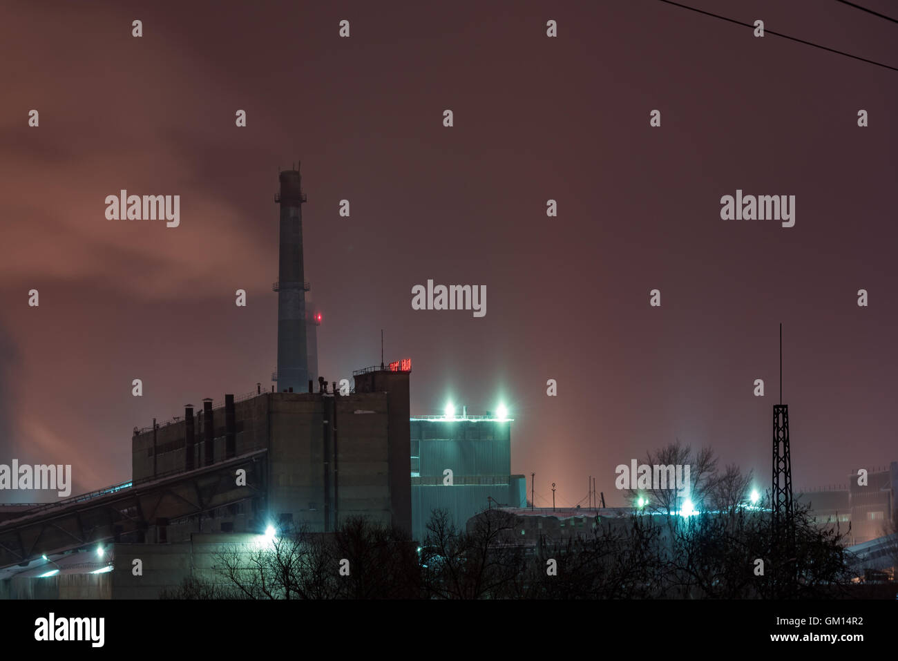 Power station with steam cloud blown by the wind in a cold starry winter night Stock Photo