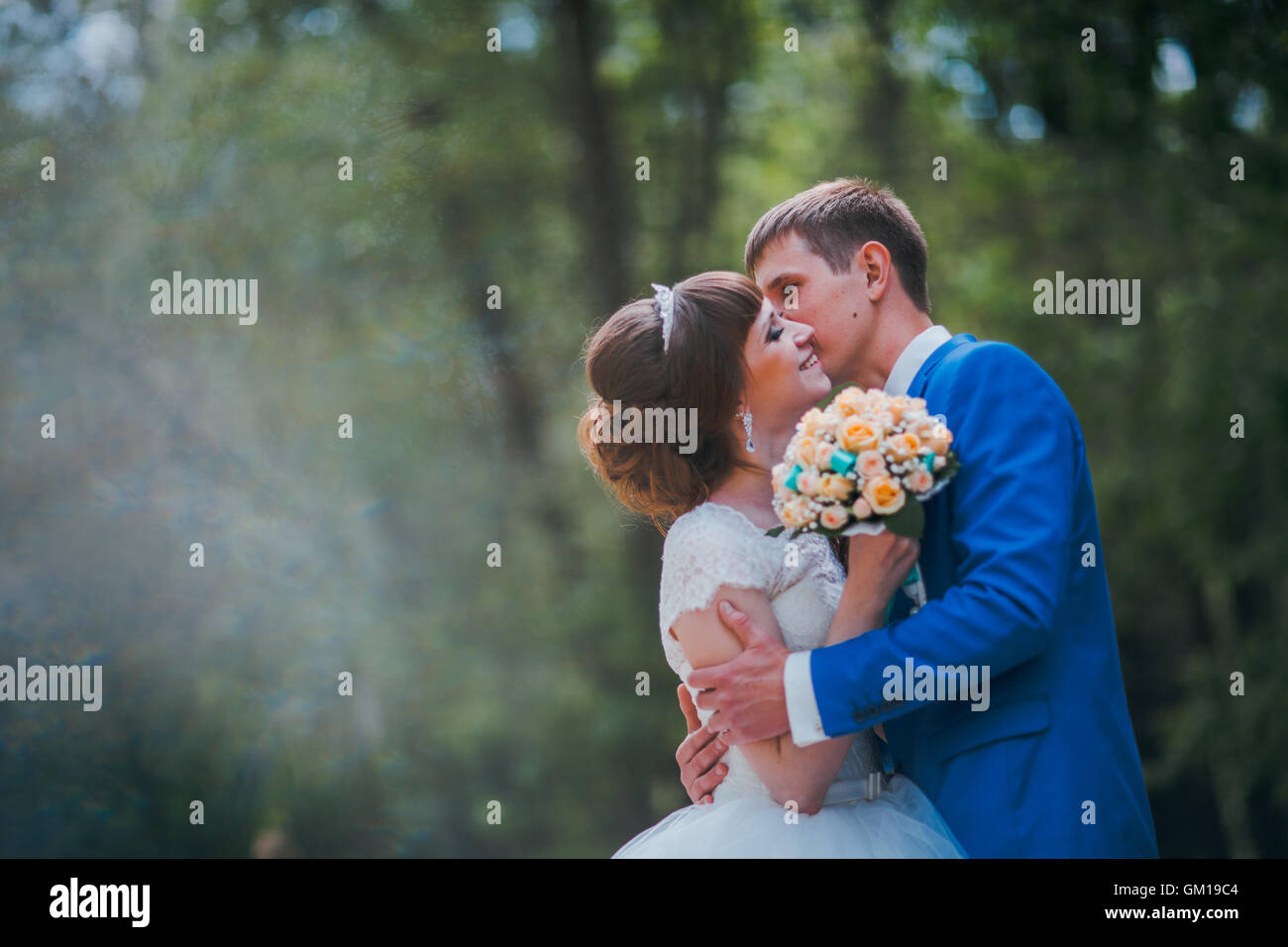 young bride and groom kissing on the background of the forest Stock ...