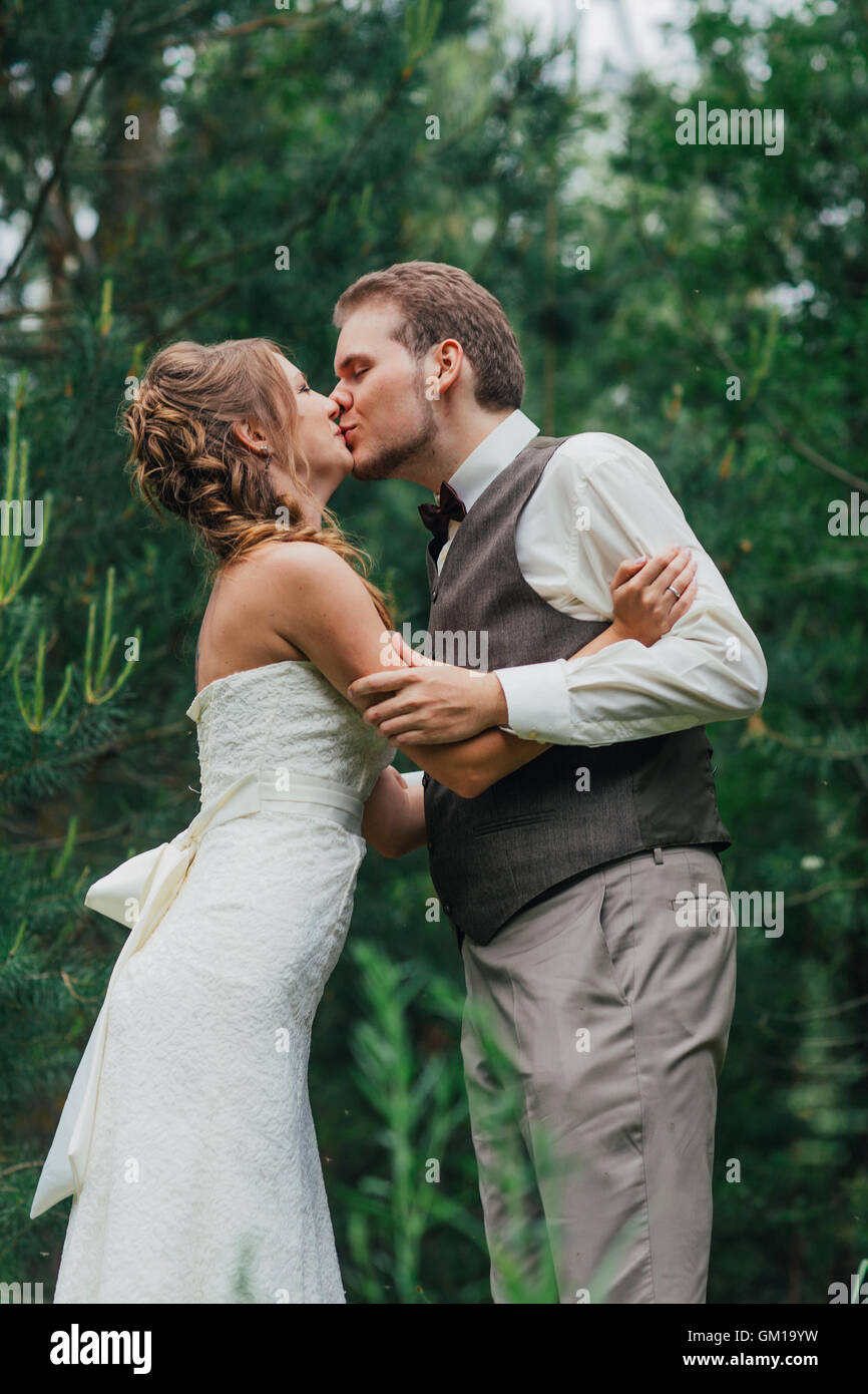 bride and groom kissing on the background of forest Stock Photo - Alamy