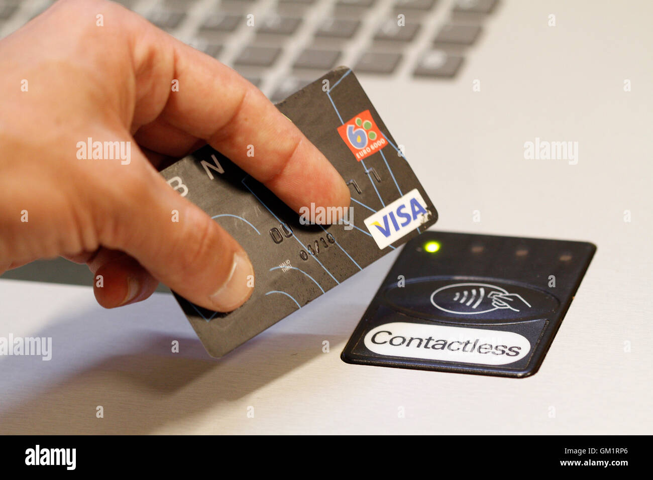 A customer paying using contactless credit cards payment system. Stock Photo