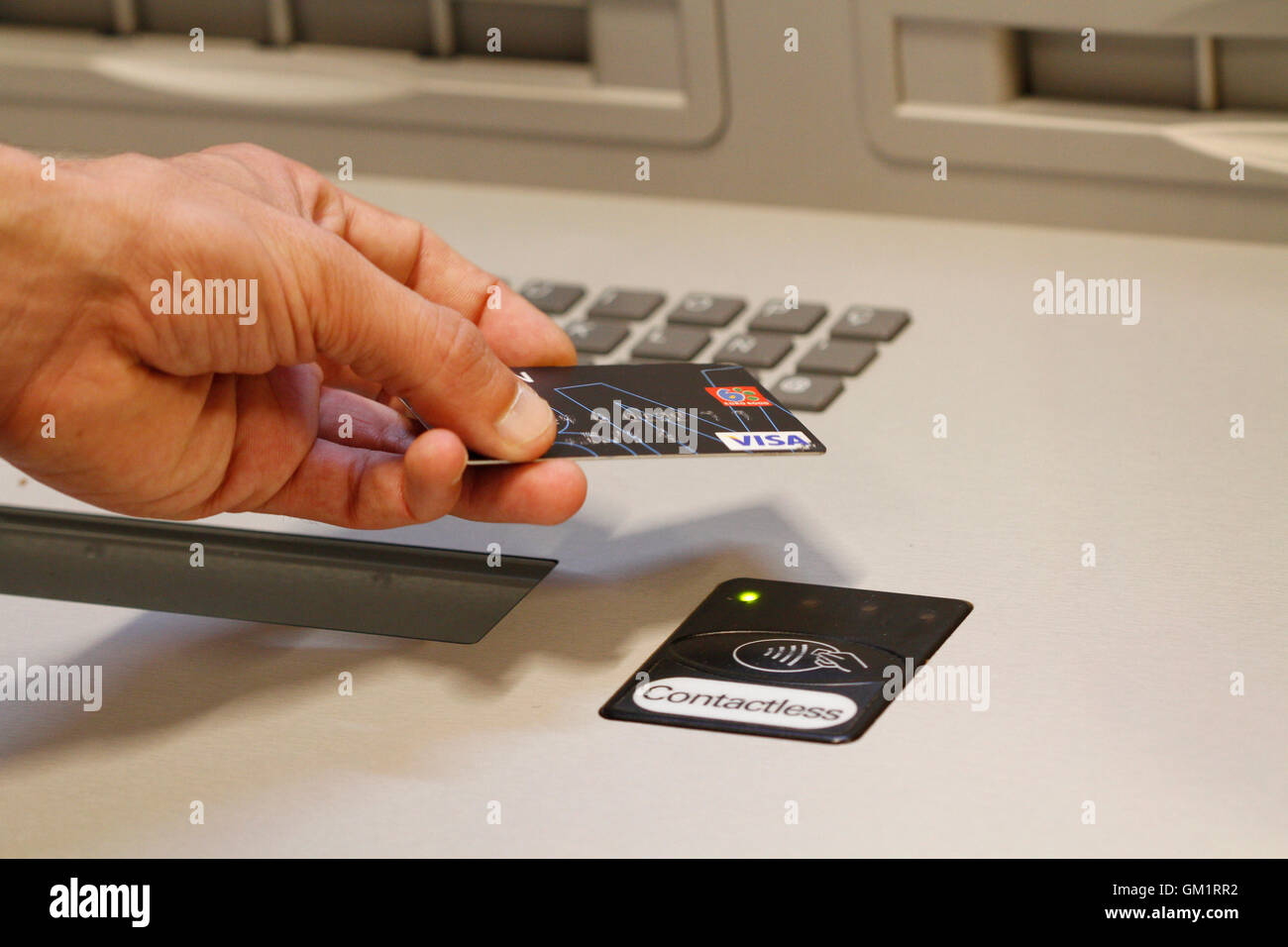 A customer paying using contactless credit cards payment system. Stock Photo