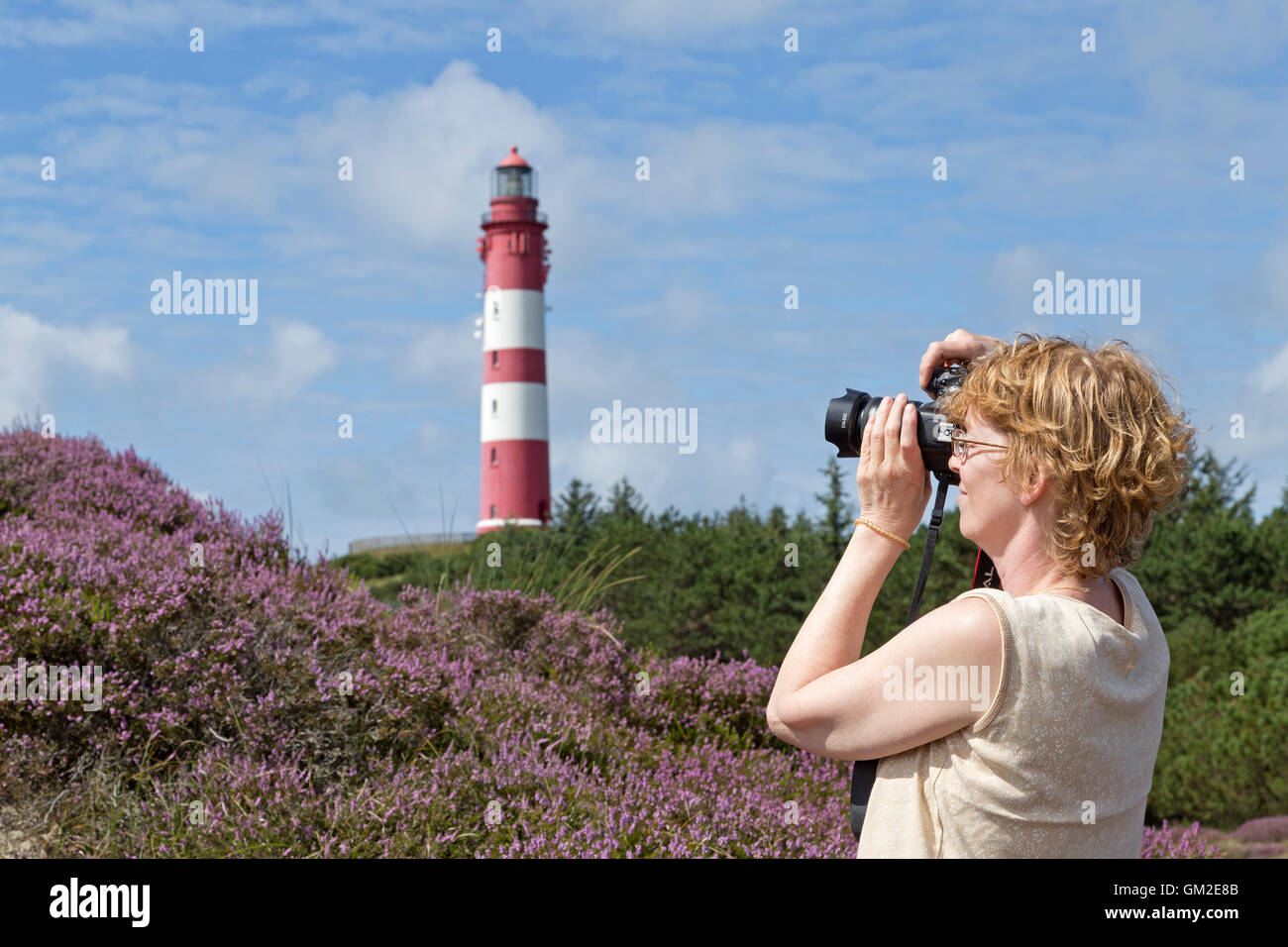 woman taking photos of the lighthouse, Amrum Island, North Friesland, Schleswig-Holstein, Germany Stock Photo