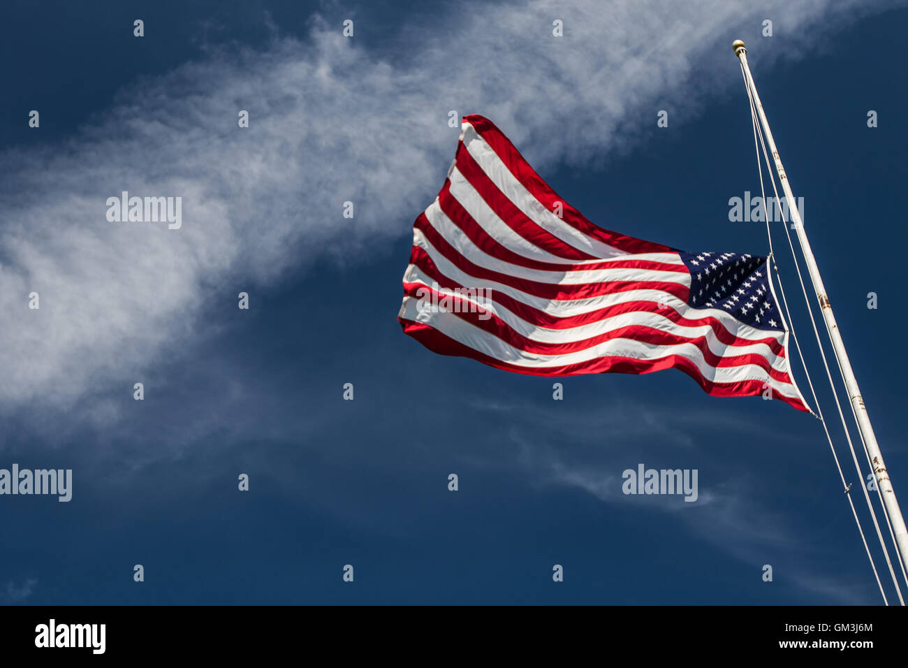 An American flag is flapping in the wind on a bright summer day. Stock Photo