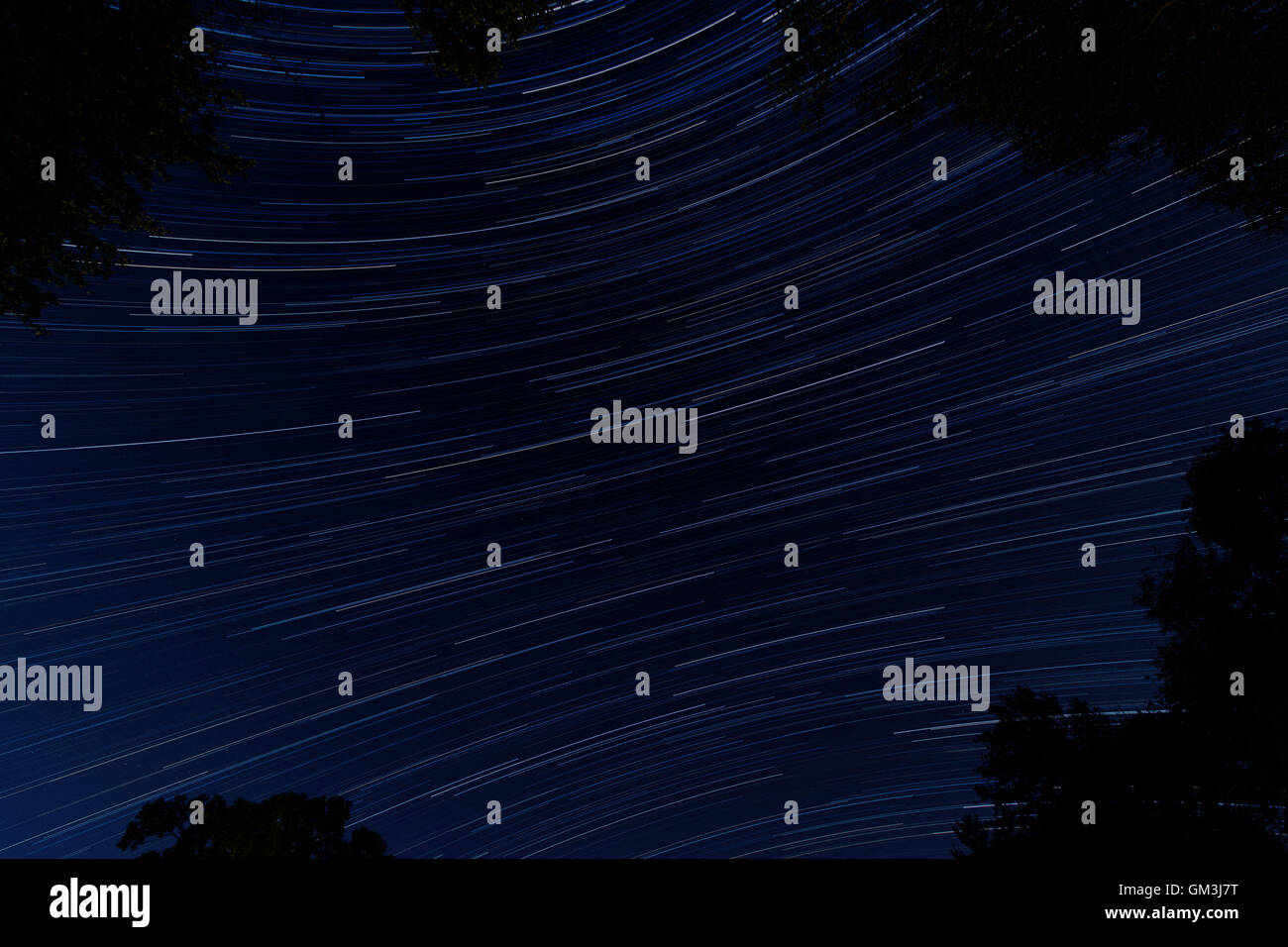 Stacked images of the night sky to create a star trail effect. Stock Photo